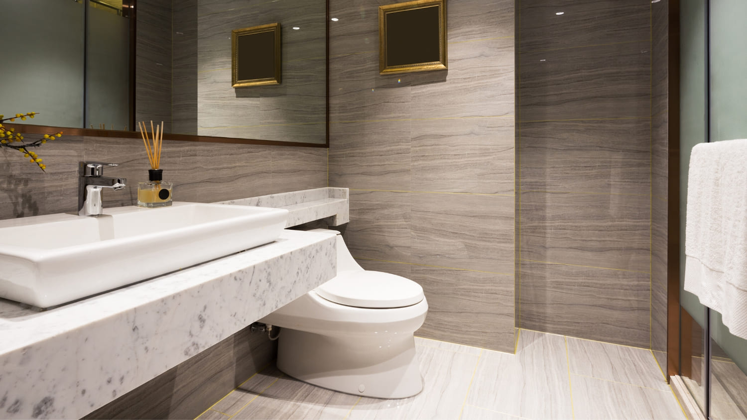 A modern and high end bathroom with gray tile on floors and walls