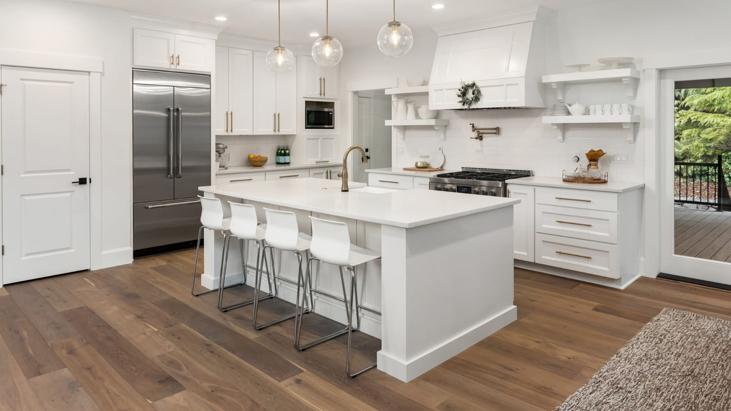 A clean white kitchen with dark wood floors